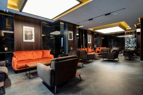 a lobby with couches and chairs in a building at Seraphine Plaza in Peje