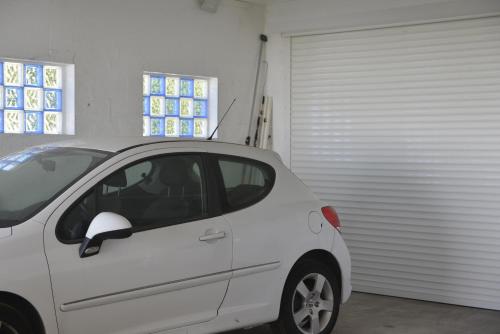a white car parked in front of a garage at Villa Des Remparts in Sainte-Marie