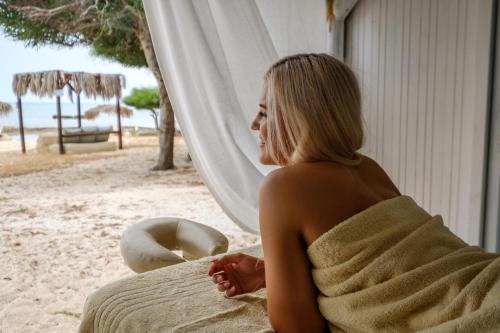 a woman sitting on the beach looking out a window at Thalassines Villas in Ayia Napa