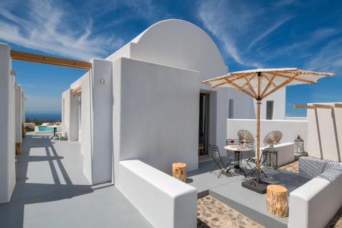 a white house with a patio with an umbrella at MILESTONE VILLAS in Megalokhori