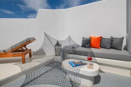 a living room with a couch and a glass of wine at MILESTONE VILLAS in Megalokhori