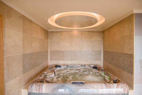 a large bath tub in a room with a circular ceiling at Park Hotel Latgola in Daugavpils