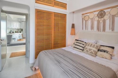 a white bedroom with a bed with pillows on it at MILESTONE VILLAS in Megalokhori