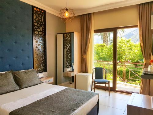 1 dormitorio con cama y ventana grande en Papirus Hotel, en Adrasan