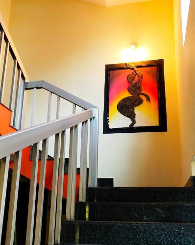 a staircase with a picture of a woman on the wall at Indian Art Villa in Varkala