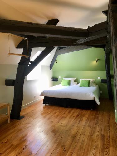 une chambre avec un grand lit dans un grenier dans l'établissement La Maison du Grand Four, à Mercurey