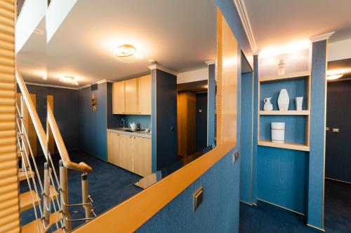 a staircase in a room with blue walls and wooden cabinets at Park Hotel Latgola in Daugavpils