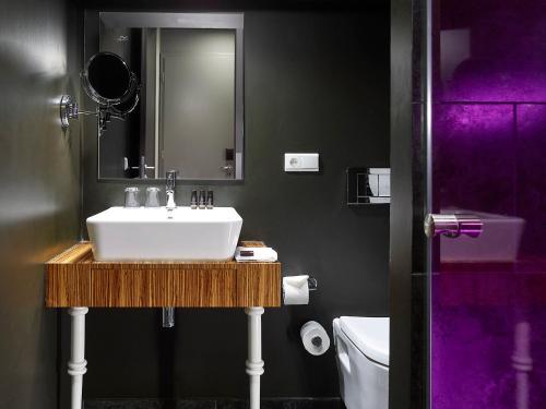 a bathroom with a white sink and a mirror at The ICON Hotel & Lounge in Prague