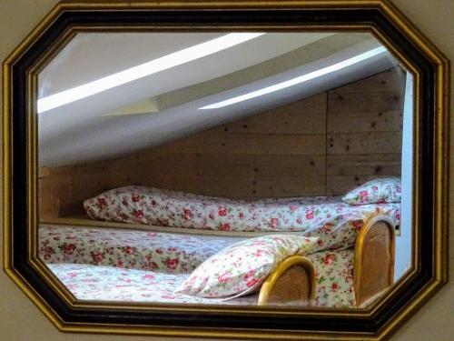 a mirror reflecting two beds with pillows in a room at Le Mimose B&B in Vinci