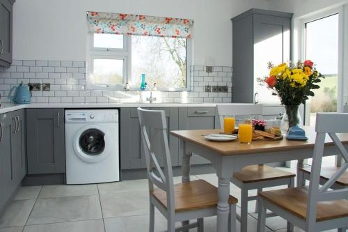 a kitchen with a table and a washing machine at Bramble Cottage in Rathfriland