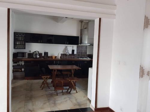 a kitchen with a table and chairs in a room at Chambre d'hôtes Valiha in Ivato