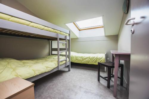 2 Etagenbetten in einem Zimmer mit einem Schreibtisch und einem Fenster in der Unterkunft LE SOLEIL DE JADE village vacances in Préfailles