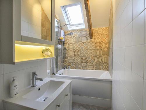 a bathroom with a sink and a bath tub at Little Bakehouse in Criccieth