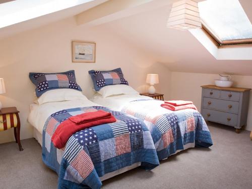 two beds in a attic bedroom with a skylight at Old Barns - Pentre Berw in Llangristiolus