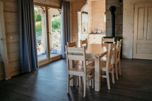 uma cozinha com uma mesa de madeira e cadeiras num quarto em Osada Witów - dom "Miłosna Górska" em Witów