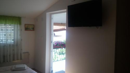 a room with a window and a television on the wall at Apartments Timi in Poreč