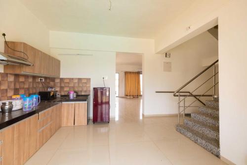 a kitchen with a refrigerator and a staircase at Vivaant Retreat and Conventions in Igatpuri