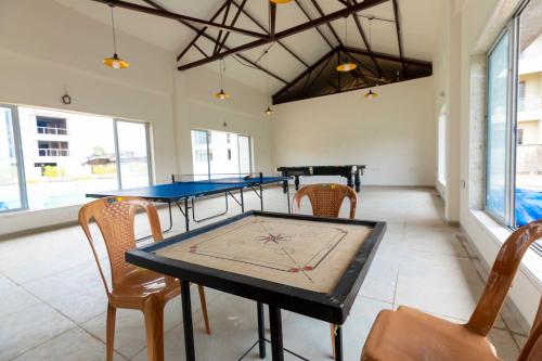 a room with two ping pong tables and chairs at Vivaant Retreat and Conventions in Igatpuri