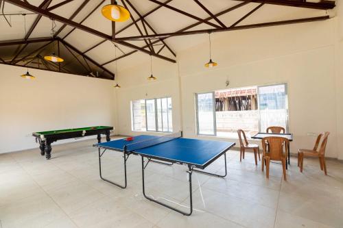 a large room with a ping pong table and chairs at Vivaant Retreat and Conventions in Igatpuri