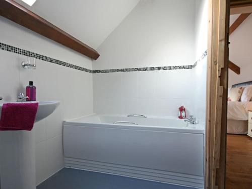 a bathroom with a white tub and a sink at Hendre in Llanllyfni