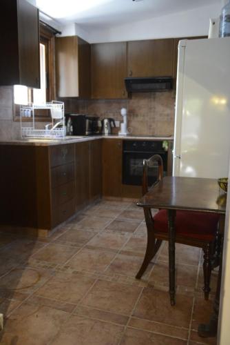 a kitchen with a table and a white refrigerator at Crambero Suites in Alona