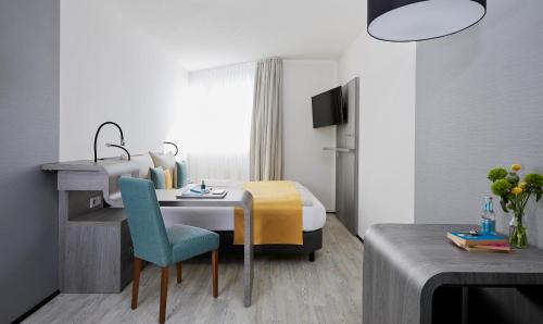 um quarto de hotel com uma cama e uma mesa e cadeira em Living Hotel am Deutschen Museum em Munique