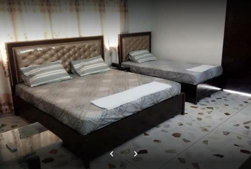 two twin beds in a room with at E-Town Rooms Guest House in Karachi