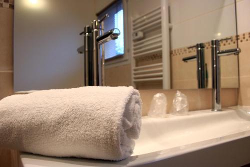 ein Badezimmer mit einem weißen Handtuch auf einem Waschbecken in der Unterkunft Villa Martégale Hôtel Restaurant in Martigues