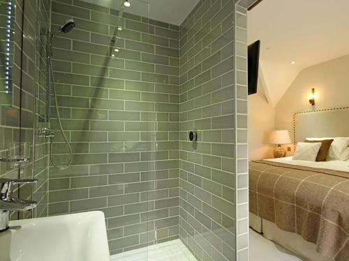 uma casa de banho com um chuveiro e uma cama em Harlech Apartments - Matholwch em Harlech
