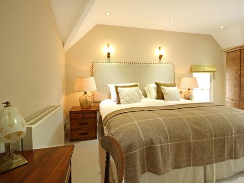 a bedroom with a bed and two lamps and a table at Harlech Apartments - Matholwch in Harlech