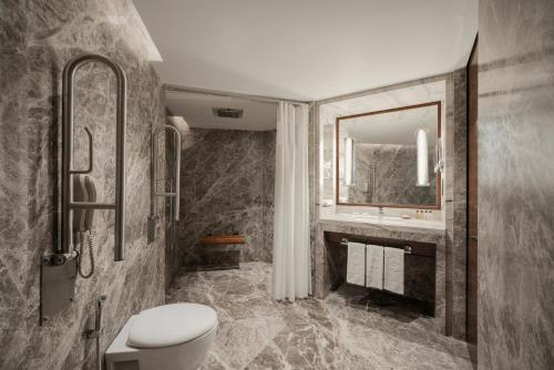 a bathroom with a toilet and a sink and a mirror at Shangri-La Eros New Delhi in New Delhi