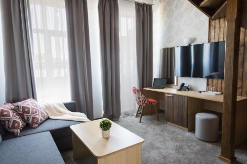 ein Wohnzimmer mit einem Sofa und einem Schreibtisch in der Unterkunft Hotel Central in Ruse
