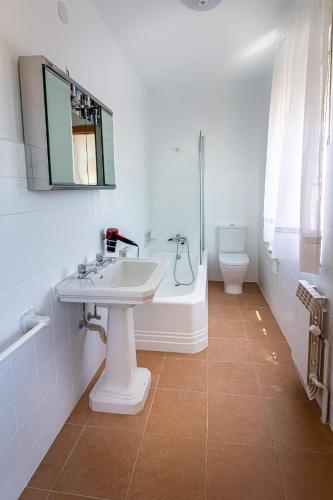 a bathroom with a sink and a tub and a toilet at Pensión Casa do Gallo Sarria in Sarria