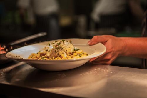 a person holding a bowl of food on a counter at New Continental Hotel; Sure Hotel Collection by Best Western in Plymouth