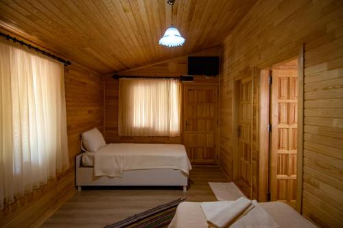 Likya Adrasan Otel في أدراسان: غرفة نوم بسريرين في كابينة خشبية