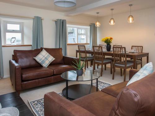 a living room with a couch and a table at Stabl Bach in Llanfaethlu