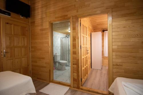 a bathroom with a toilet in a room with wooden walls at Likya Adrasan Otel in Adrasan
