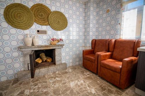a living room with a chair and a fireplace at Pensión Casa do Gallo Sarria in Sarria