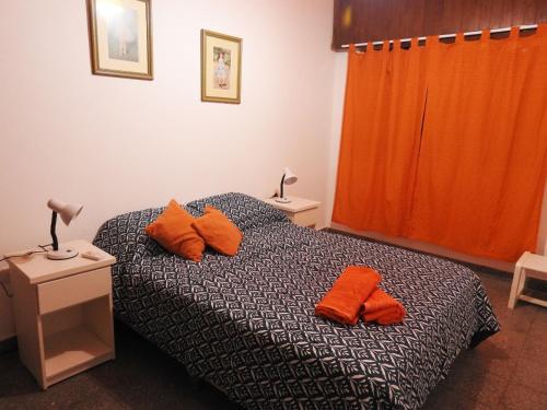 a bedroom with a bed with orange pillows on it at IRUÑA CENTRO- 150 mts peatonal de Resistencia in Resistencia