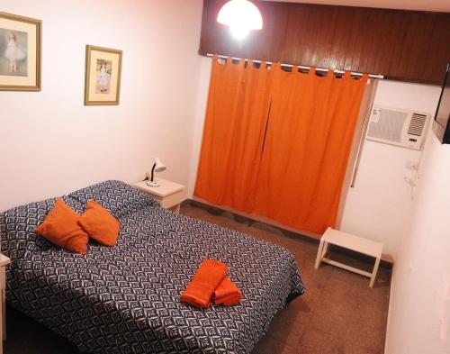 a bedroom with a bed with orange pillows on it at IRUÑA CENTRO- 150 mts peatonal de Resistencia in Resistencia