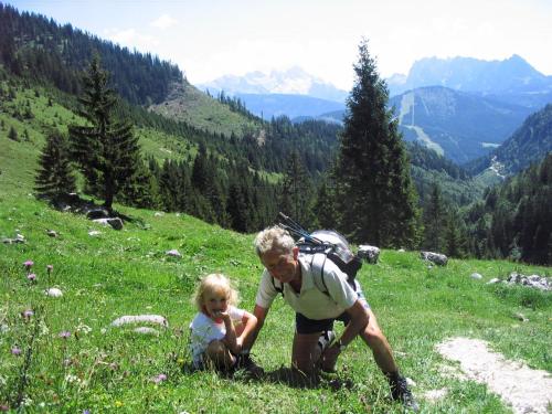 a woman and a child on a grassy hill at Apartmenthaus Oberlehen in Abtenau