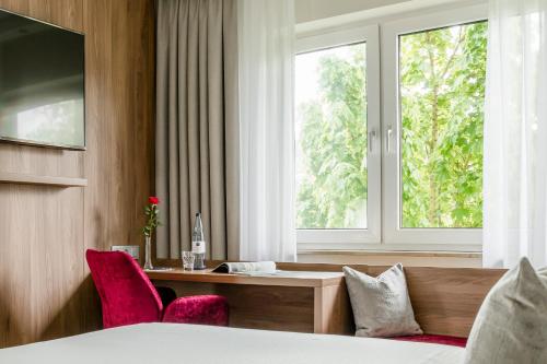 a hotel room with a desk and a window at Dorint Parkhotel Siegen in Siegen
