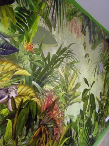 a mural of a jungle with a monkey on a wall at Das Nest in Eisenstadt