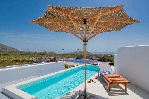 a large umbrella over a swimming pool on top of a house at MILESTONE VILLAS in Megalokhori