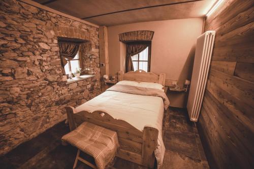a bedroom with a bed in a stone wall at B&B Ca' Mea room, wellness & food in Levata