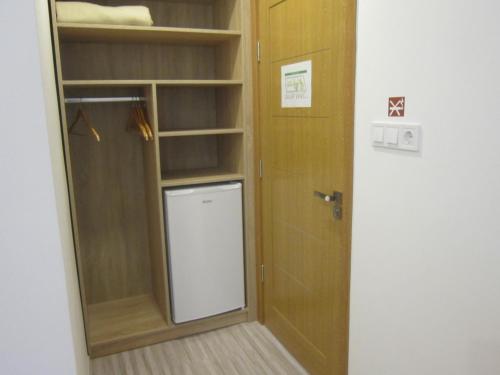 a room with a closet with a door and a shelf at Fehér Hajó Panzió és Vendéglő in Győr