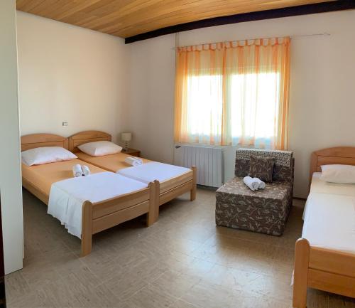 1 dormitorio con 2 camas, silla y ventana en Apartments Marinko, en Trogir