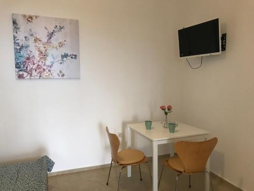 um quarto com uma mesa e duas cadeiras e uma televisão em Studio apartment Milla em Rijeka