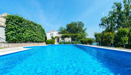 einen Pool mit blauem Wasser vor einem Haus in der Unterkunft Villa Idila in Mostar