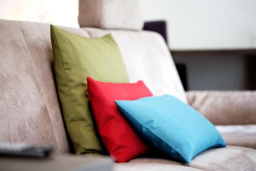 two colorful pillows sitting on a couch at Boardinghouse by M&K in Bad Oeynhausen